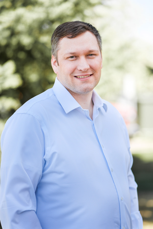 portrait of Dr. Olson, white man smiling broadly with light brown hair, standing outside